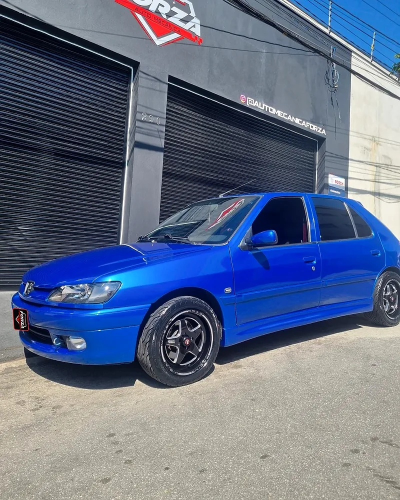 Peugeot 306 azul na frente da Forza